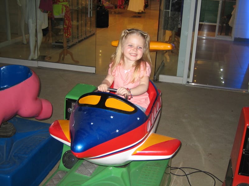 Marie riding a toy airplane