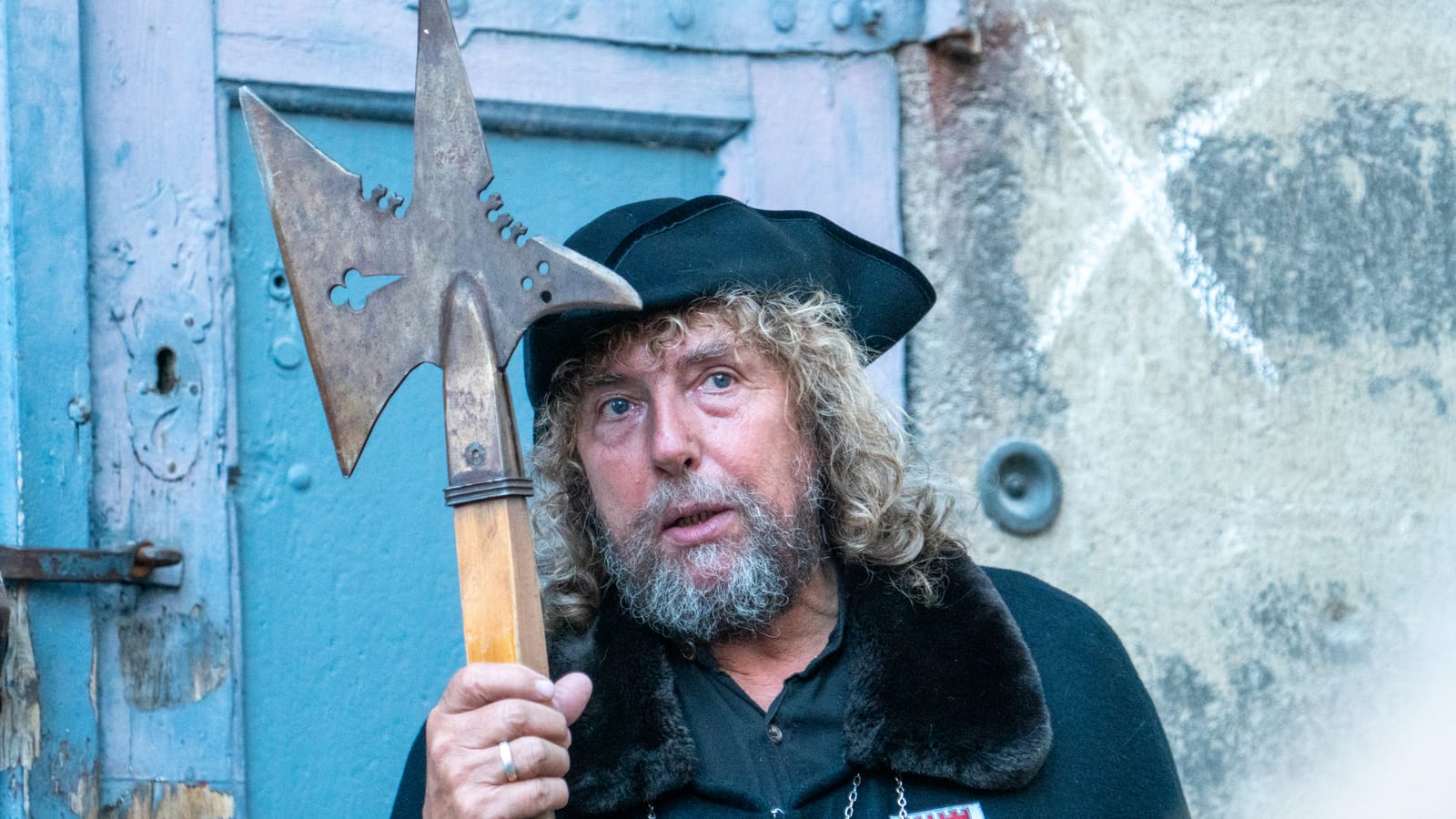 The night watchman in his black cloak and hat, holding a halberd on a Rothenburg street